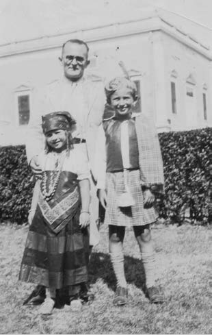 Norman and Barbara in masquerade costumes, with Dad, 1932 or 1933